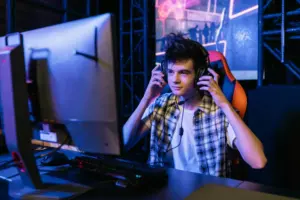 Teenager wearing a headset while gaming at a desk