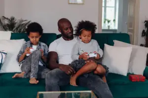Family playing video games together on a sofa