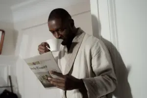 Person reading a newspaper with morning coffee